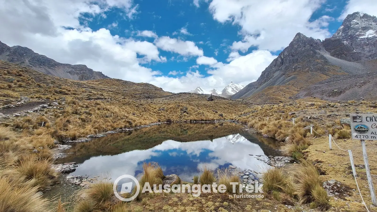 Ch'uñu Qocha reflecting clouds and snow peaks at the highest point of the 7 Lakes hike
